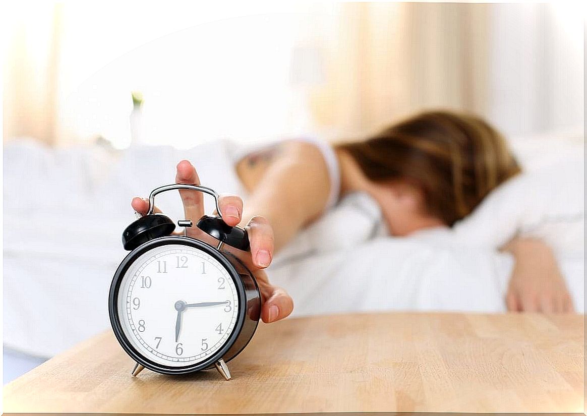 Woman turns off alarm clock