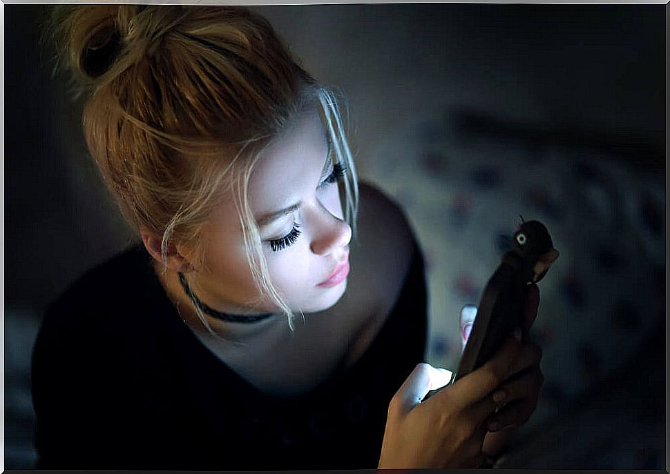 Screen usage and eye health: Woman uses cell phone in the dark