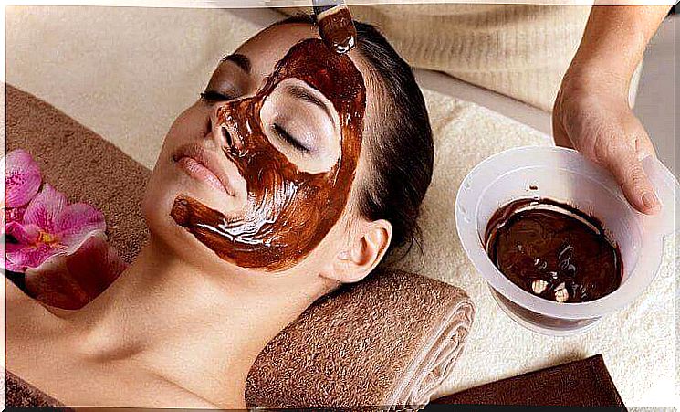 A mask made of chocolate and almond oil is applied to a woman.