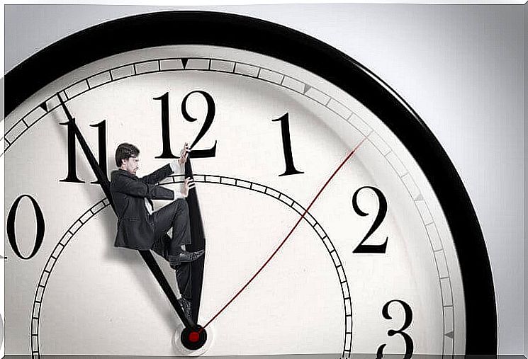 A man is standing on the hand of a clock.