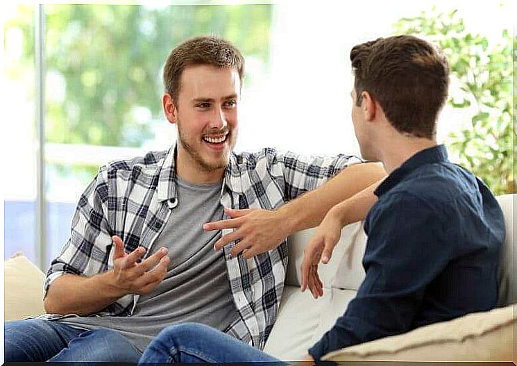 Two men talk to each other and laugh.