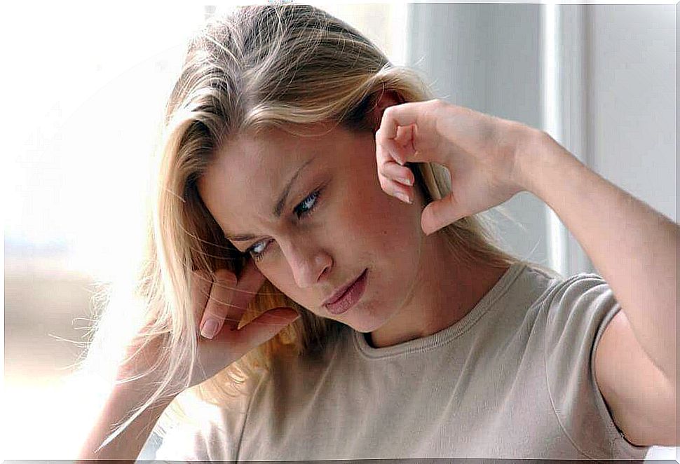 Woman covers her ears because she needs an earache remedy.